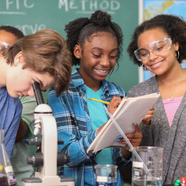 Students exploring science together with a microscope and laboratory materials.